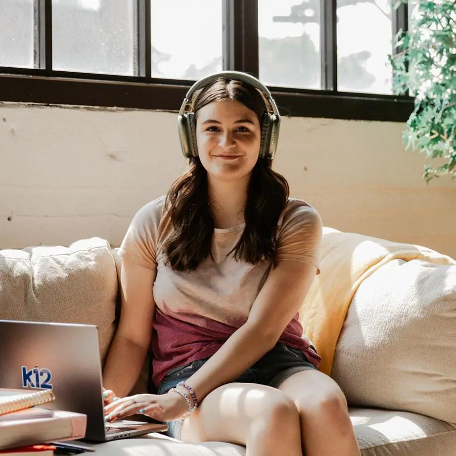 Ardayga oo xidhan laba taleefoon oo dhegaha la gashado iyadoo isticmaalaysa laptopkeeda