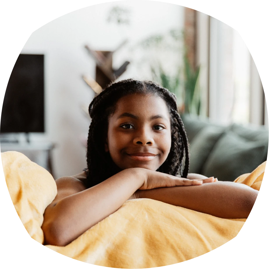 Gabar yar oo timo tidcan ayaa ku tiirsatay sariir, iyadoo si diiran u dhoola cadeyneysa. Waxay ku duudduubtay buste jaale ah, oo qol fadhi oo raaxo leh gadaal kaga yaal.