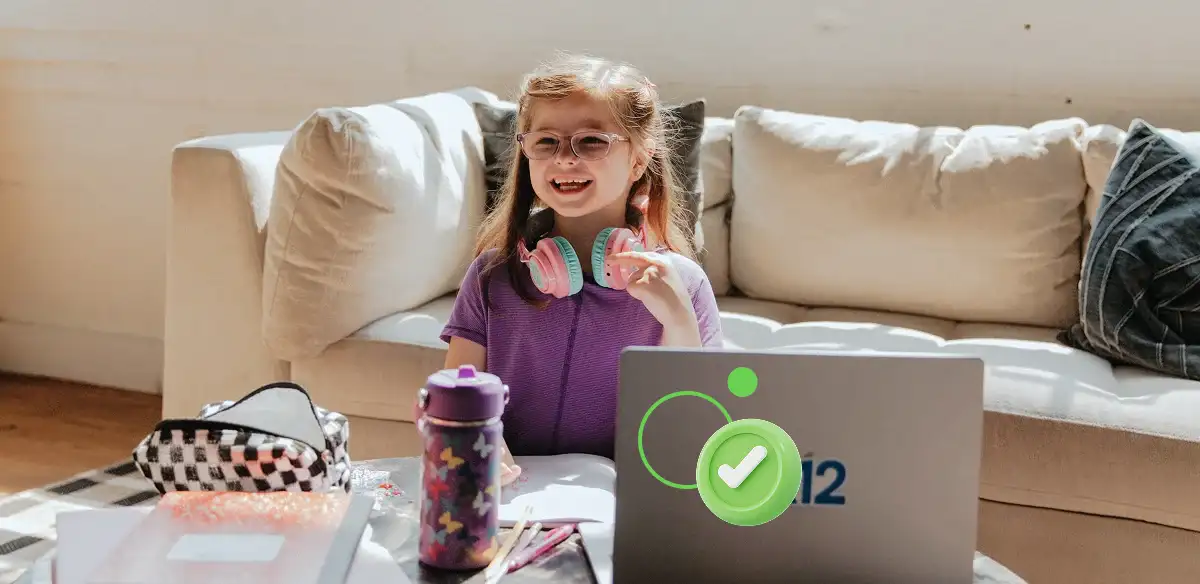 Ardayad dugsi hoose oo ka shaqaynaysa laptop-keeda guriga iyadoo xiran sameecado casaan ah